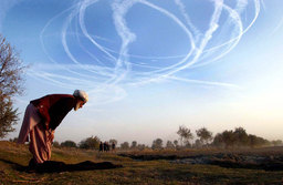 A man prayed as a US fighter jet flew overhead at the frontline, North Afghanistan, November 2001