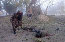 Northern Alliance troops lay in the road after a tank shell landed on their position, North Afghanistan, November 2001